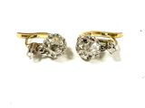 deux paires de boucles d'oreilles en diamant posées sur une surface blanche