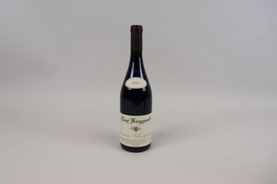 une bouteille de vin rouge posée sur une table blanche