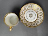 a close up of a cup and saucer on a table