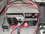 a black and red power supply sitting on a bed