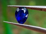 un gros plan sur une pince tenant un diamant bleu