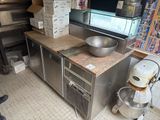 une cuisine avec un grand saladier en métal posé sur le plan de travail