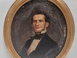 portrait of a man in a suit and bow tie in a gold frame