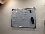 a white board with writing on it hanging on the wall