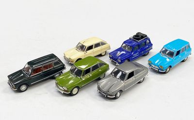 plusieurs petites voitures sont alignées sur une surface blanche