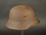 an old helmet on a metal stand on a gray background