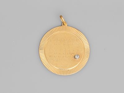 a gold medal with a diamond in the center