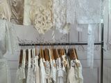 a lot of dresses hanging on a rack in a room
