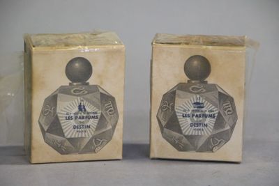 two boxes of perfume sitting on top of a table next to each other