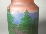 un vase avec un tableau posé sur une table