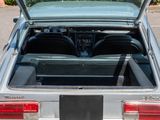 a silver car with its trunk open in a parking lot