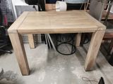 a wooden table that has a black wire on it