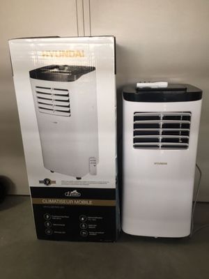a white air conditioner sitting next to a black and white box
