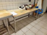 a workbench in the middle of a kitchen with a lot of clutter on it
