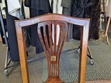 a chair that is sitting in front of a rack of clothes
