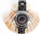 a picture of a watch sitting on a seashell
