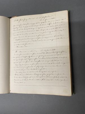un livre ouvert avec une écriture dessus, posé sur une table