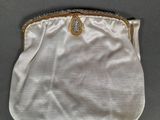 a white purse with a gold clasp on it