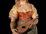 statue of a woman with a mandolin sitting on a black surface