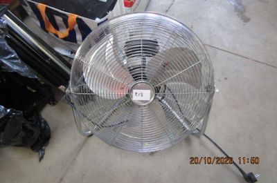 un ventilateur posé par terre à côté d'une moto