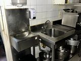 many pots and pans on the counter in this kitchen