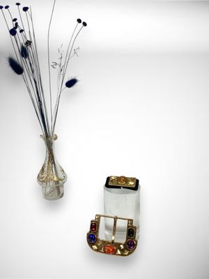 a vase with flowers in it and a cell phone on the wall
