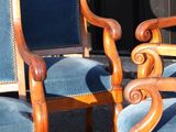 two blue chairs sitting next to each other on the street