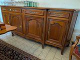 un buffet en bois avec une table et une chaise dans un coin