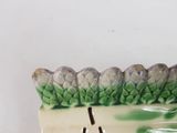 a ceramic figurine of a hedge on a white background