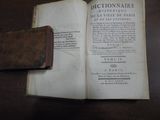 un livre ouvert posé sur une table, sur laquelle se trouve un portefeuille