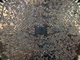 a large silver plate with intricate designs on it