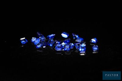 a group of blue sapphires on a black surface