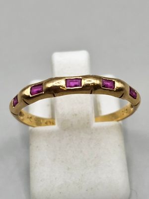 Gros plan sur une bague en or ornée de pierres roses