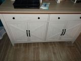 a microwave on top of a white cabinet in a kitchen