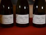 three bottles of wine sitting on a table next to each other