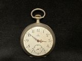 a silver pocket watch sitting on a black cloth
