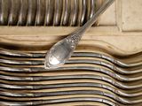 many spoons and forks in a box on the table