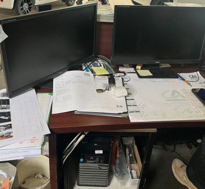 deux écrans d'ordinateur posés sur un bureau dans un bureau
