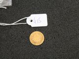a gold coin on a black surface with a price tag