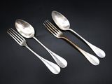 a set of three silverware spoons and fork on a black background
