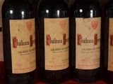 several bottles of red wine are lined up on a table