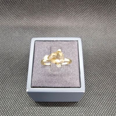 une photo d'une bague en or dans un écrin posé sur une table