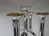 three silver candles that are sitting on a table