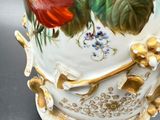 a vase with flowers painted on it sitting on a table