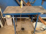 a blue table with a bottle of liquid on it