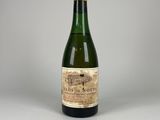 une vieille bouteille de vin posée sur une table