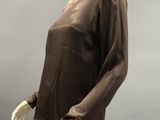 une photo d'un mannequin portant un haut marron et un pantalon blanc