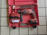 une boîte à outils rouge contenant des outils, posée sur un sol carrelé