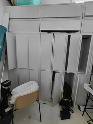 une pièce remplie de nombreuses armoires blanches et d'une planche de surf