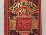 un vieux livre à la couverture rouge posé sur une table blanche